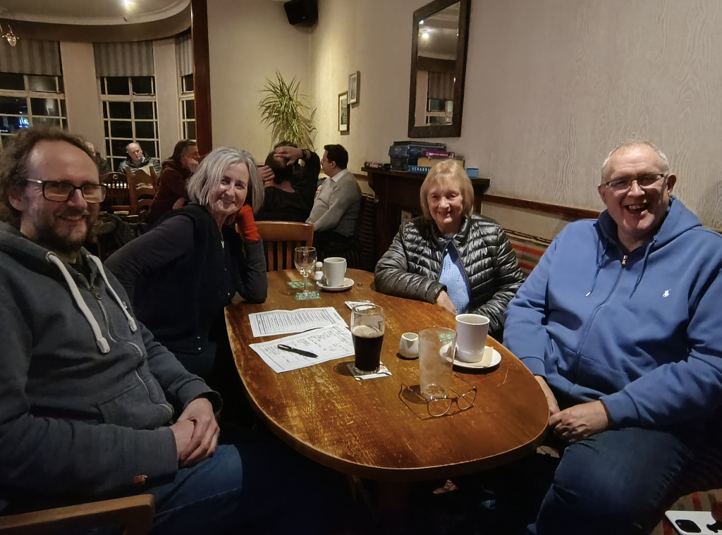 Members of the community group sat round a table at the pub quiz